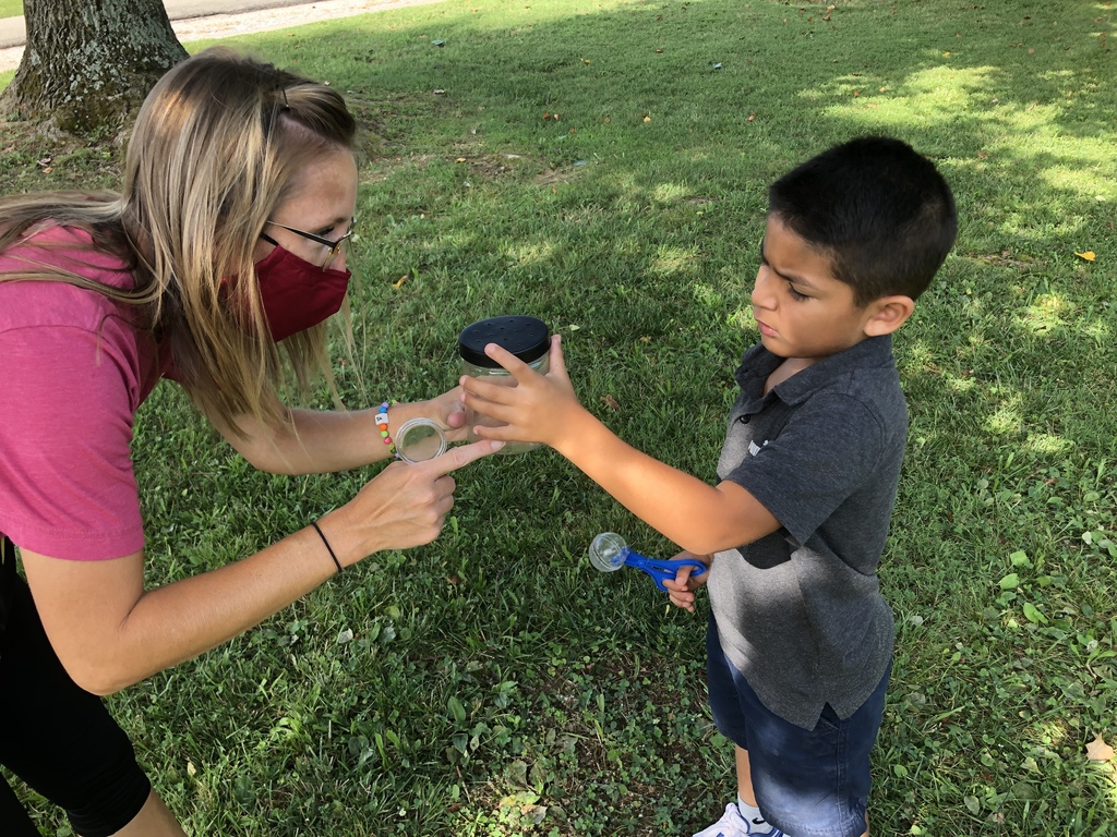 Mrs. Stites and student catching and observing insects during Summer School.